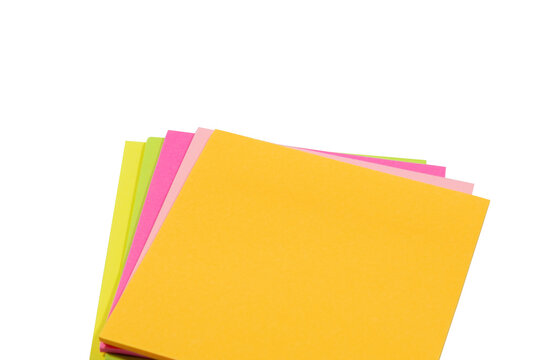 A stack of square, neon-colored adhesive paper notes in yellow, pink, and green, arranged in a layered, overlapping pile on a white background