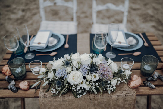 Beach wedding table with navy runners and a floral centerpiece