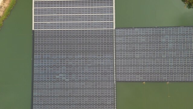 Aerial drone view of floating solar cell panel farm on water reservoir for renewable clean energy generation. Sustainable green power plant and ecology technology concept.