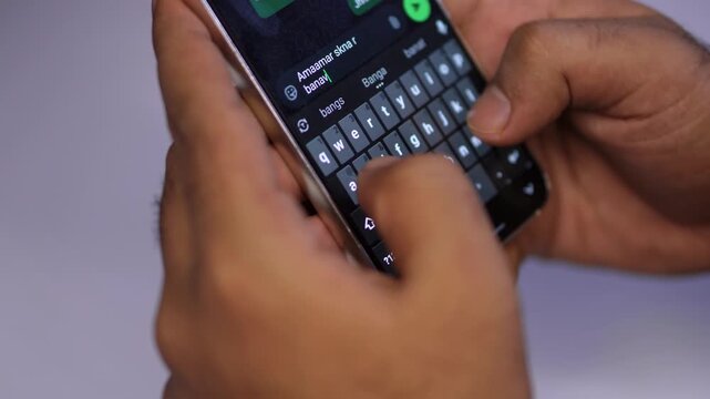 Person Typing a Message on Smartphone with Colorful Bokeh Background