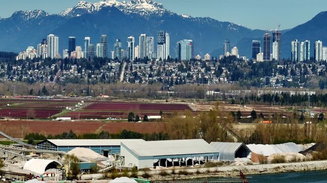 Aerial drone view of the Metrotown skyline in Burnaby, British Columbia, Canada, showing high-rise buildings, Highway 91 in the foreground, urban development, and surrounding city landscape