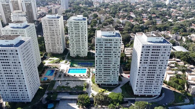 Lateral drone shot over an upscale neighborhood in S&atilde;o Paulo, showcasing luxury residential buildings and a modest residential area side by side, near Villa-Lobos Park