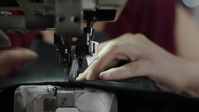 Hands sewing leather material with industrial machine in shoe production process