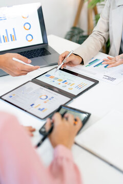 Business Team Analyzing Financial Data with Multiple Tablets and Laptop