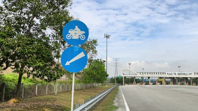 A signboard indicates a dedicated motorcycle lane at a toll plaza. It separates motorbikes from cars and other vehicles for safety and smooth traffic flow.