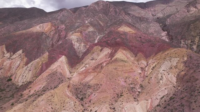 4K drone aerial view of Paleta del Pintor in Maimar&aacute;, Jujuy, Argentina. Iconic colorful mountain landscape in the Quebrada de Humahuaca, with vibrant geological layers shaped by erosion.