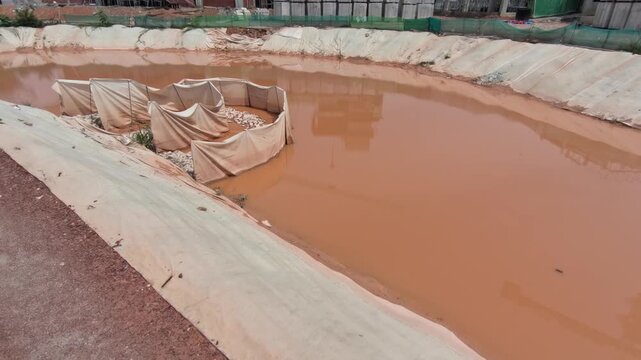 A temporary detention pond captures stormwater runoff at a construction site. It helps prevent flooding, soil erosion, and downstream silt pollution during earthworks.