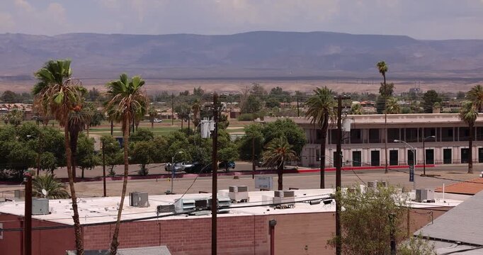 Palm trees frame the downtown buildings and mountains of Needles, California, USA.
