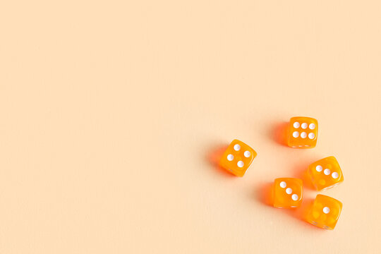 Orange game dices on beige background