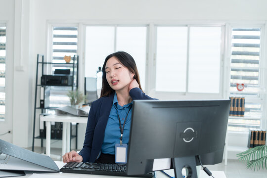 Young Businesswoman Working at Office Desk While Managing Documents and Mobile Communication.