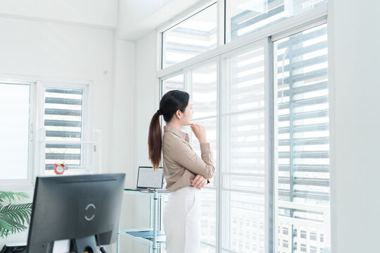 Young Businesswoman Working at Office Desk While Managing Documents and Mobile Communication.