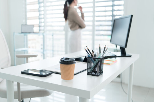 Young Businesswoman Working at Office Desk While Managing Documents and Mobile Communication.