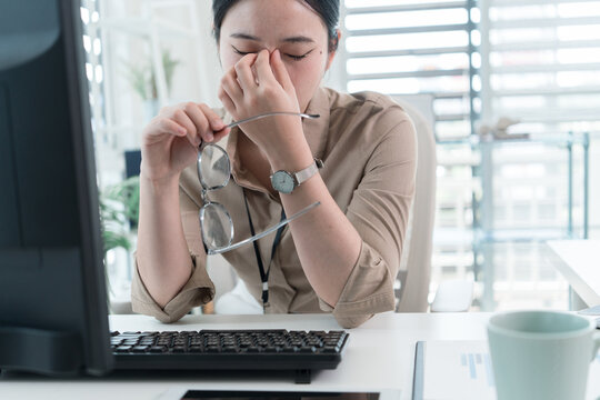 Young Businesswoman Working at Office Desk While Managing Documents and Mobile Communication.