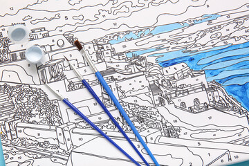 Obraz premium Paint and brushes on unfinished canvas for painting by numbers, closeup