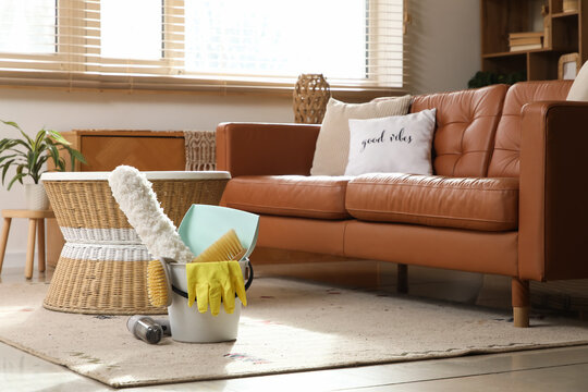 Bucket of cleaning supplies and brushes with portable vacuum cleaner in living room
