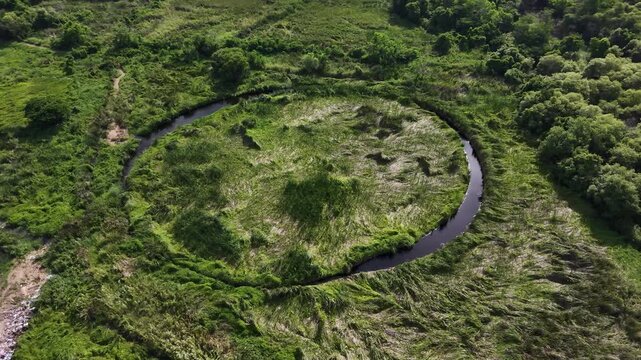Circular lagoon and grass field surrounded on top view. Hiding unseen landscape in Thailand.