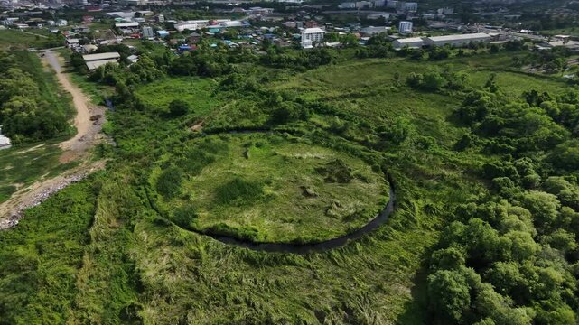 Circular lagoon and grass field surrounded on top view. Hiding unseen landscape in Thailand.