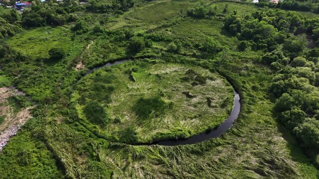 Circular lagoon and grass field surrounded on top view. Hiding unseen landscape in Thailand.