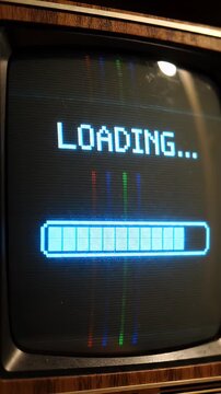 Retro Pixel Art Loading Bar on Vintage Television Screen - A pixelated "LOADING..." text and a blue progress bar are displayed on a vintage CRT television screen.