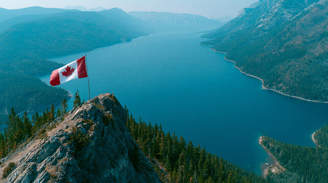 Canadian flag displayed on a rocky summit with a stunning mountain lake vista.