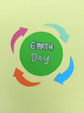 Earth Day symbol promoting recycling, sustainability and environmental awareness through colorful circular arrows and bold typography.