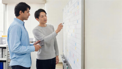 Fototapeta premium 職場で外国人スタッフに勤務表の見方を説明するOJT