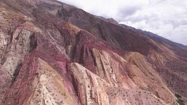 4K drone aerial view of Paleta del Pintor in Maimar&aacute;, Jujuy, Argentina. Iconic colorful mountain landscape in the Quebrada de Humahuaca, with vibrant geological layers shaped by erosion.