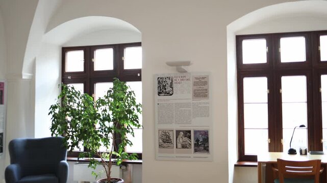 Quiet library interior with empty study desk bookshelves reading chair and large windows creating a peaceful academic environment for learning research and focused study
