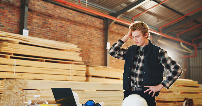 Stress, man and carpenter in workshop with laptop, bad news and feedback for incorrect timber. Concern, male person and tech at warehouse for carpentry deadline, wrong order and production rejection