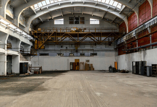 Interior view of an abandoned industrial factory building with high arched ceiling and metal crane industrial building