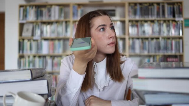 Student listens to an AI voice assistant during a library study session wondering whether its answer is reliable before using the information for her academic research today