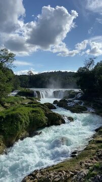 Cinematic shot of the spectacular Cascadas Las Nubes in Chiapas, Mexico, featuring stunning turquoise-blue water flowing over rocky cascades in the lush jungle