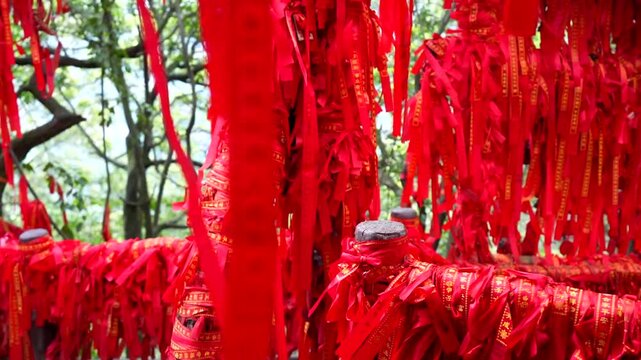 Red prayer ribbons with Chinese calligraphy hanging on a wishing tree in Yuanjiajie scenic area