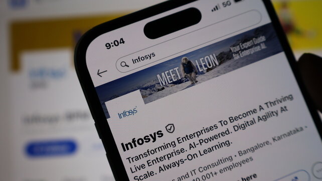 Infosys profile page displayed on smartphone screen against blurred office background showcasing corporate digital presence.