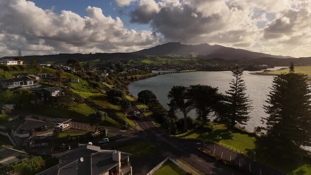 Aerial view of truck driving along coastal route beside estuary with Mount Karioi background in New Zealand