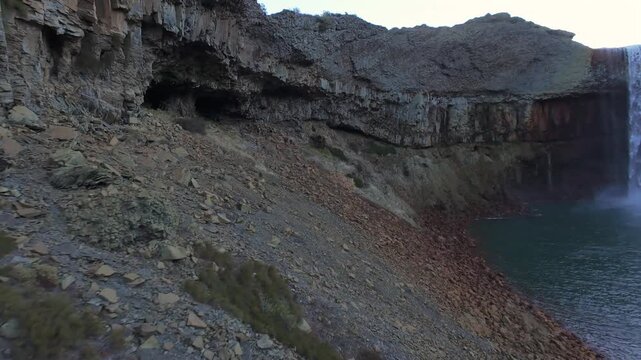 Drone dynamic fpv swoop approaching cliff edge of Salto del Agrio waterfall framed by rocky cliffs in Neuquen, aerial
