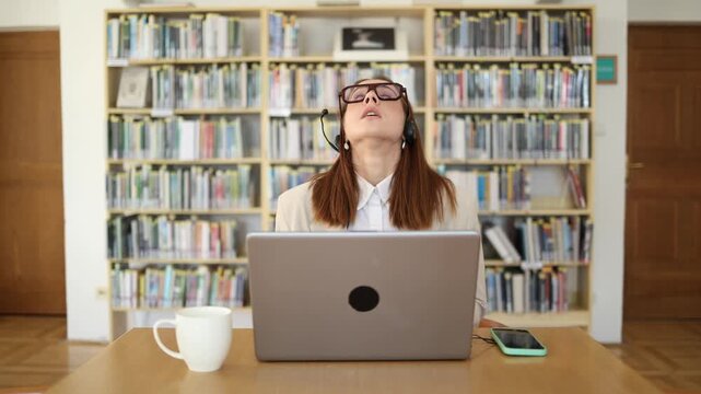 Frustrated call center employee suddenly loses patience and nervously pulls off her headset while working on laptop overwhelmed by stressful customer service work