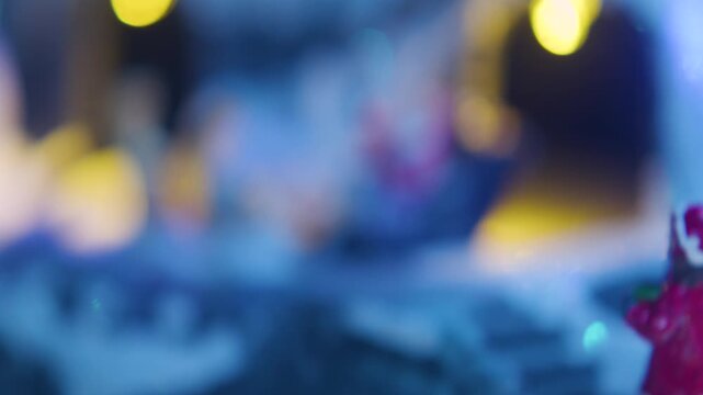 Cinematic 4K push-past shot moving beyond a girl in a red coat to reveal Santa Claus riding his sleigh with reindeer along a snowy path in a festive Christmas village.