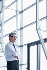 Thinking, smile and arms crossed with business man in office for vision, insurance broker and ceo. Portfolio manager, reflection and claims advisor with mature employee in agency for risk management