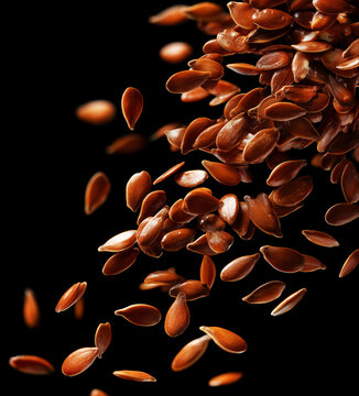 Glossy brown flax seeds isolated on a dark background with clipping path, depicting natural texture and organic nutrition concept