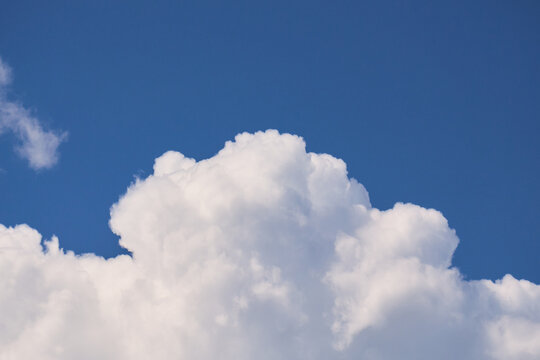 Beautiful cinematic shot of heavy dense cumulus clouds gathering in a blue sky on a warm summer day