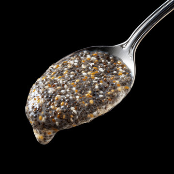 Closeup of spoon filled with chia seeds isolated on black background with clipping path, concept of nutrition and healthy eating