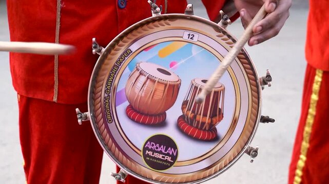 Person playing a traditional drum at an Indian celebration