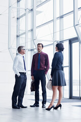 Fototapeta premium Office, talking and business people in lobby for conversation, chat and update at finance agency. Corporate, team and men with woman for discussion, meeting and financial consulting in workplace
