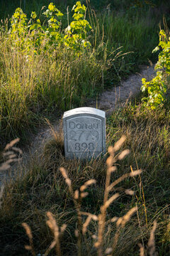 Historic First Danube river kilometer marker stone standing in grass near Donaueschingen ideal for travel guides