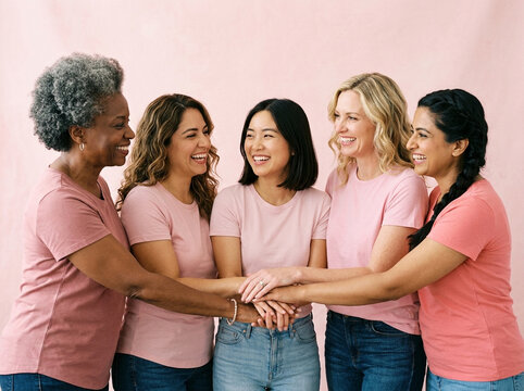Diverse group of women stacking hands together in unity