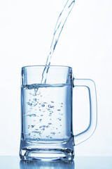 a stream of drinking water flows into a glass cup creating bubbles © dmitr1ch