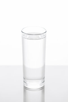 glass cup with crystal clear water on table in greyish tones