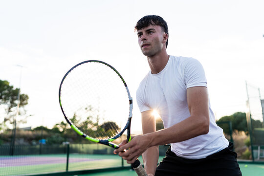 Young man holding tennis racket ready to play