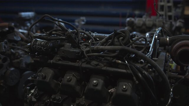 arrangement and display of engine components in an industrial or workshop environment close-up shot focusing on engine parts with technical and mechanical mood.